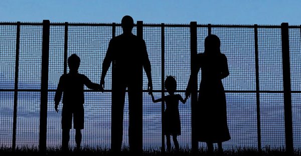 Immigrant Family By Chain Link Fence